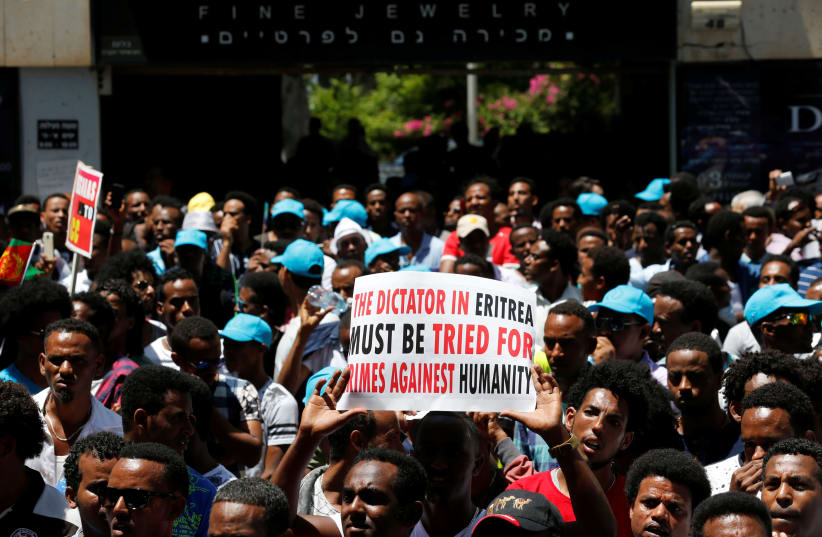 Eritrean refugees hold placards during a demonstration in support of a recent U.N. report that accused Eritrean leaders of committing crimes against humanity, outside the E.U. offices in Ramat Gan, Israel (photo credit: AMIR COHEN/REUTERS)