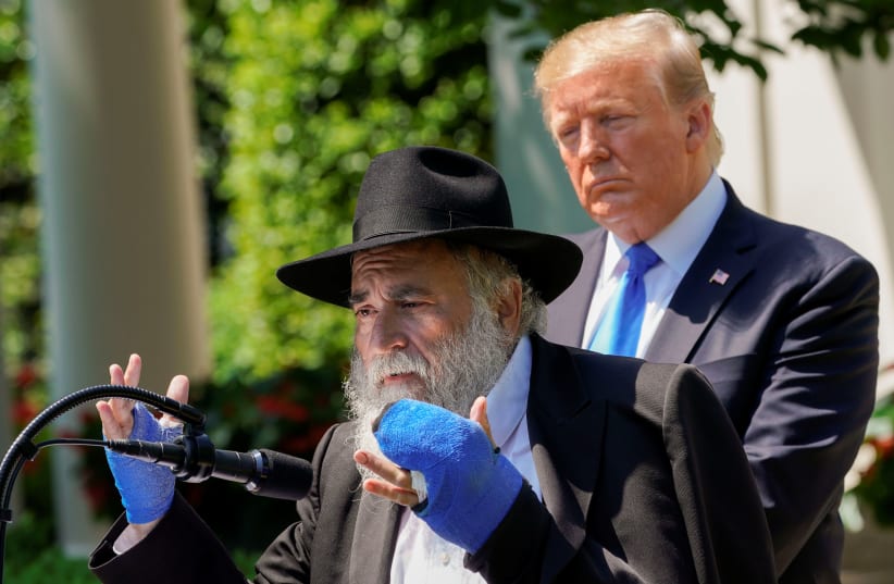 Rabbi Yisroel Goldstein, injured in the recent shooting at the Congregation Chabad synagogue in Poway, California, speaks as U.S. President Donald Trump looks on, May 2, 2019 (photo credit: KEVIN LAMARQUE/REUTERS)