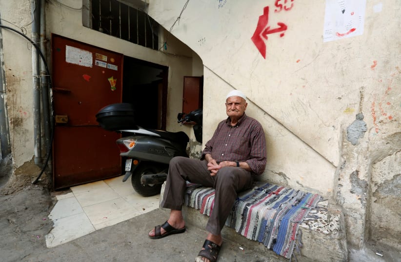 Palestinian refugee Abu Ahmad sits at Shatila refugee camp, in Beirut (photo credit: JAMAL SAIDI/ REUTERS)