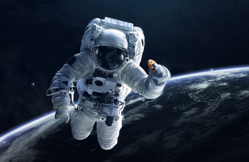 An illustration of an astronaut with a DoubleTree by Hilton Cookie (photo credit: BUSINESS WIRE)