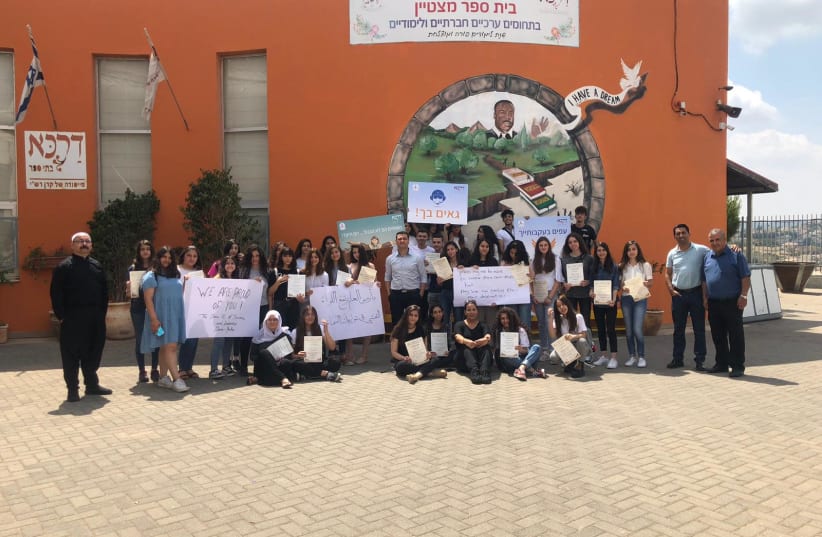 Students and staff of the school where G. graduated from in a picture congratulating him (photo credit: DARCA)