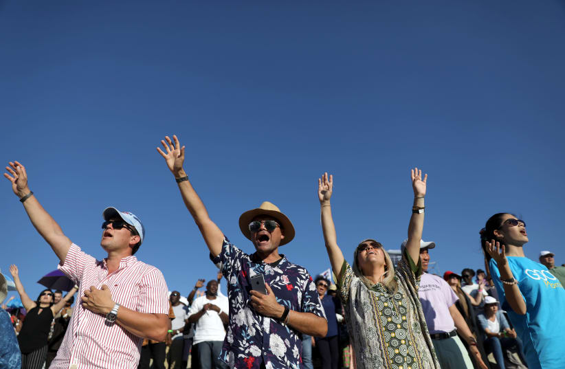 Christian pilgrims and tourists react during a religious retreat lead by T.B. Joshua, a Nigerian evangelical preacher on Mount Precipice, Nazareth (photo credit: AMMAR AWAD / REUTERS)