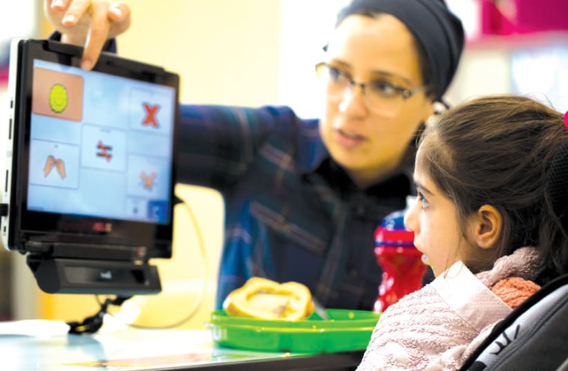 A NONVERBAL resident uses eye-tracking technology to communicate with her teacher at ALEH’s special education school in the Negev. (photo credit: ALEH)