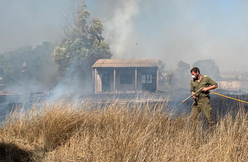 IDF soldier fighting flames near Kibbutz Mefalsim (photo credit: Courtesy)