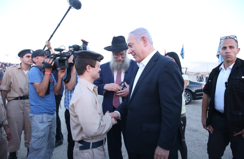 Prime Minister meets Tarc Tuba, 23, a Druze with Down’s syndrome who is part of the 'Special in Uniform' initiative (photo credit: SPECIAL IN UNIFORM)