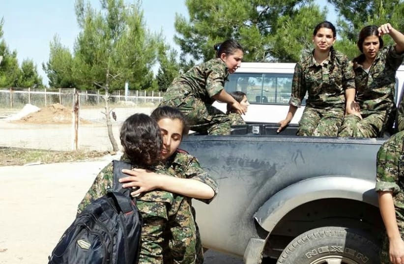 YPJ fighters hug after a fight  (photo credit: Wikimedia Commons)