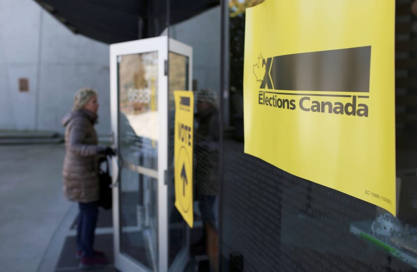 A woman enters a polling station during the Burnaby South federal by-election in Burnaby, British Columbia, Canada, February 25, 2019. (photo credit: REUTERS/BEN NELMS)