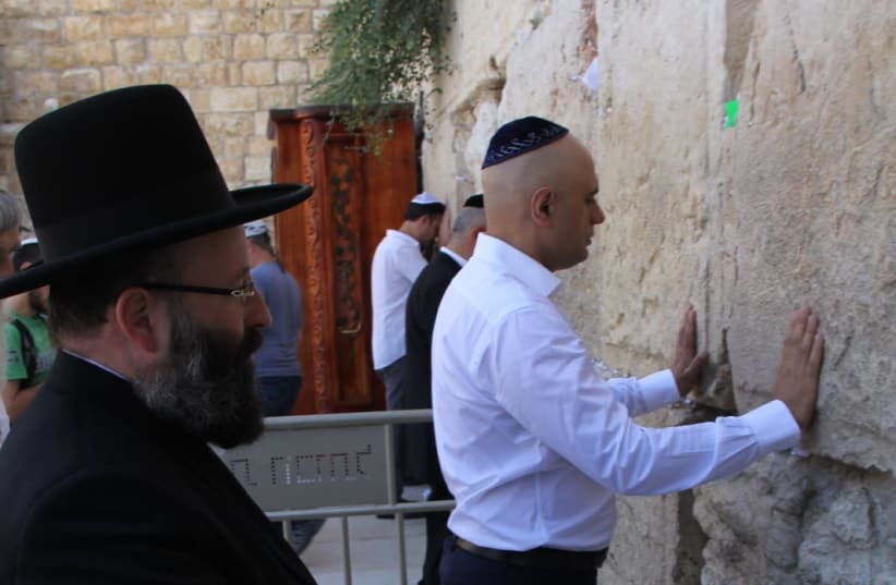 British Home Secretary Sajid Javid stands at the Western Wall alongside Chief Rabbi of the Western Wall, Rabbi Shmuel Rabinowitz, July 1 2019 (photo credit: THE WESTERN WALL HERITAGE FOUNDATION)