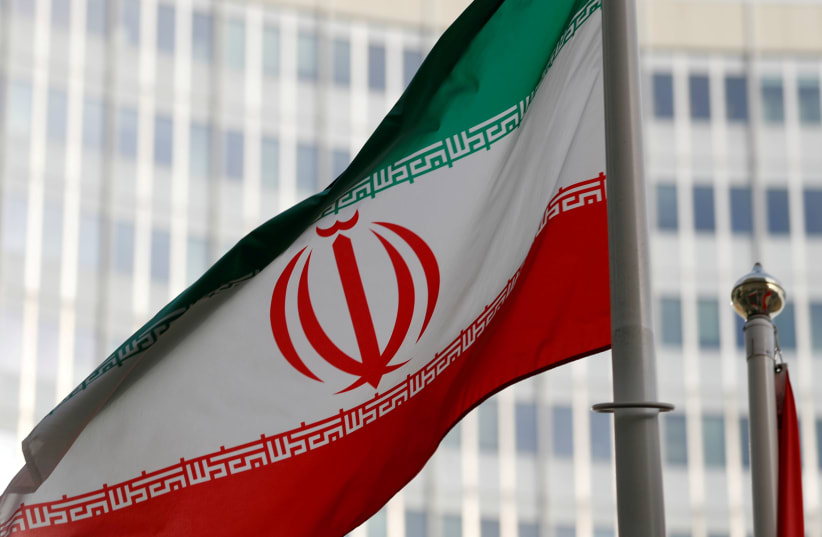 The Iranian flag flutters in front of the International Atomic Energy Agency (IAEA) headquarters in Vienna last March (photo credit: REUTERS/LEONHARD FOEGER)