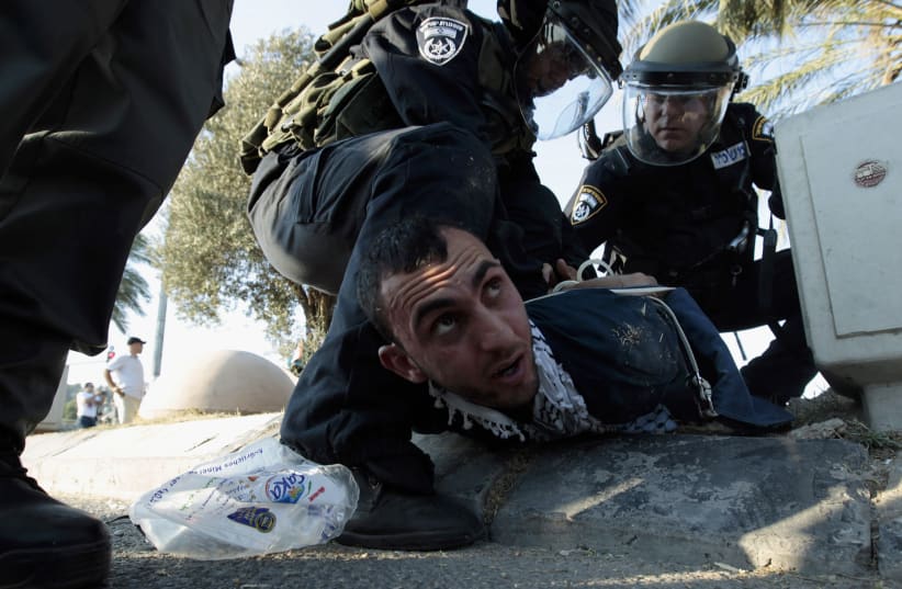 Israeli policemen detain a protester during clashes in the Israeli-Arab town of Umm el-Fahm (photo credit: AMMAR AWAD/REUTERS)