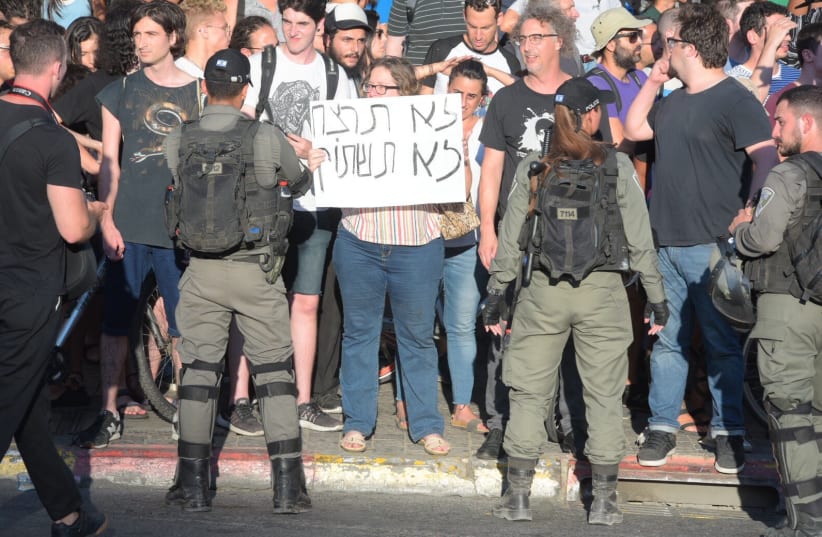 A protester holding a sign saying 'Thou shalt not kill, thou shalt not be silent'   (photo credit: AVSHALOM SASSONI)