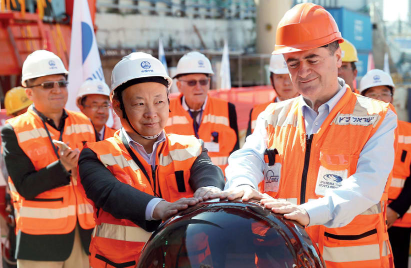 Previous transportation minister Israel Katz and employees of the China Railway Engineering Corporation take part in an event in 2017 marking the beginning of underground construction work of the Tel Aviv light rail, using a Tunnel Boring Machine (TBM) (photo credit: BAZ RATNER/REUTERS)