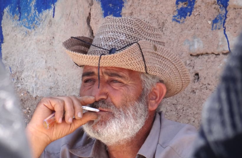 Vendor smokes cigarette in Russian Bazaar - Jolfa - Iranian Azerbaijan - Iran (photo credit: ADAM JONES/WIKIMEDIA COMMONS)