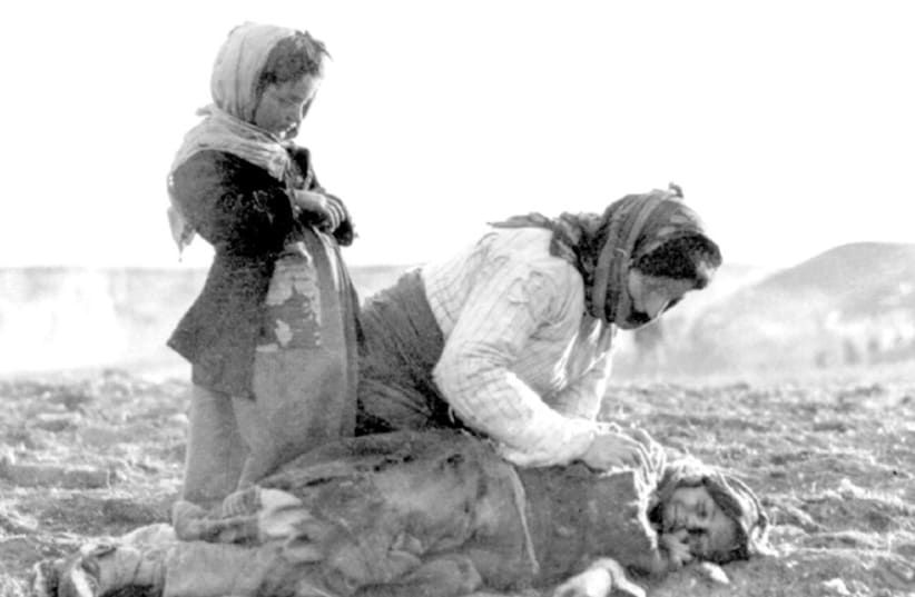 An Armenian woman kneeling beside a dead child in a field “within sight of help and safety at Aleppo.” (photo credit: WIKIMEDIA)