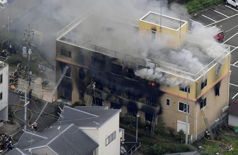 An aerial view shows firefighters battling fires at the site where a man started a fire after spraying a liquid at a three-story studio of Kyoto Animation Co. in Kyoto, western Japan (photo credit: REUTERS)