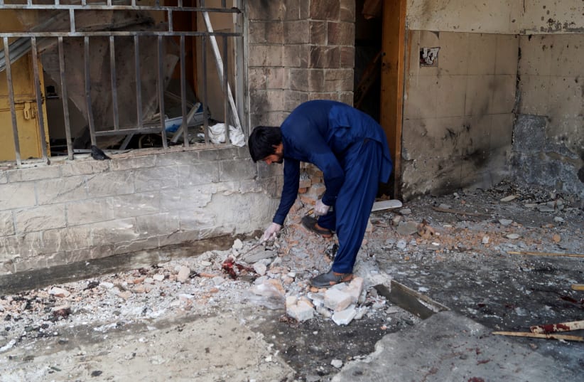A police officer in plainclothes collects the evidence from the site of a suicide blast at the premises of the Civil Hospital in Dera Ismail Khan, Pakistan July 21, 2019 (photo credit: REUTERS/STRINGER)
