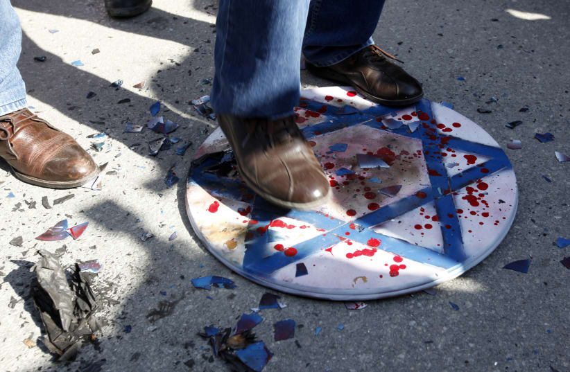 Demonstrators step on a Star of David during a protest against Israel (photo credit: UMIT BEKTAS / REUTERS)