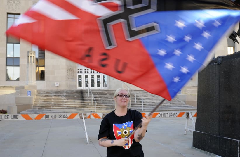  A supporter waves her flag during a neo-Nazi rally at the Jackson County Courthouse in Kansas City, Missouri (photo credit: DAVE KAUP / REUTERS)