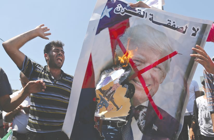 PALESTINIAN DEMONSTRATORS burn a crossed-out poster depicting US President Donald Trump that reads: ‘no for Deal of the Century’ during a protest against the Bahrain workshop last month. (photo credit: IBRAHEEM ABU MUSTAFA / REUTERS)