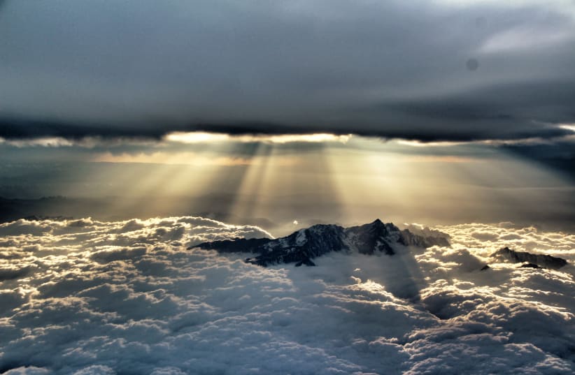 Sun penetrating the clouds above the mountains near Chengdu, China. "It looks like Genesis to me," says Tomer (photo credit: TOMER ZADOK)