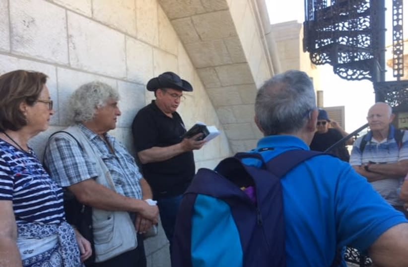 Uzi Dayan stands outside the Hurva Synagogue in the Old City, reading passages from a Tanach (photo credit: REBECCA ARATEN)