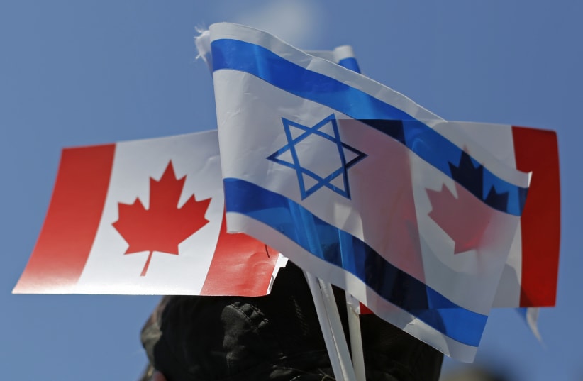 Canadian and Israeli flags are seen during a demonstration in support of Israel, on Parliament Hill in Ottawa (photo credit: REUTERS/CHRIS WATTIE)