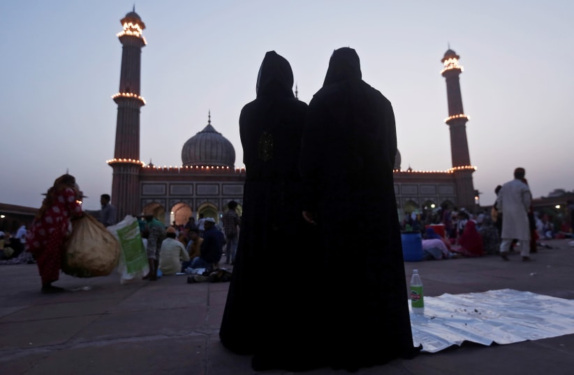 Muslim women stand as they pray after eating their iftar (breaking fast) meal during the holy month of Ramadan (photo credit: REUTERS/ADNAN ABIDI)