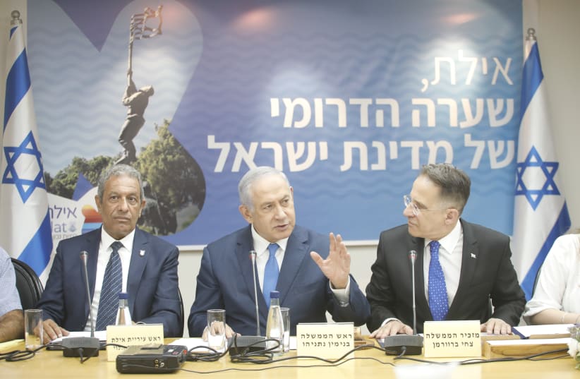 Prime Minister Benjamin Netanyahu (C) attends a cabinet meeting in Eilat, flanked by Cabinet Secretary Tzachi Braverman (R), and Mayor of Eilat Meir Yitzhak Halevi (L), August 2019  (photo credit: OLIVIA FITUSSI/HAARETZ)