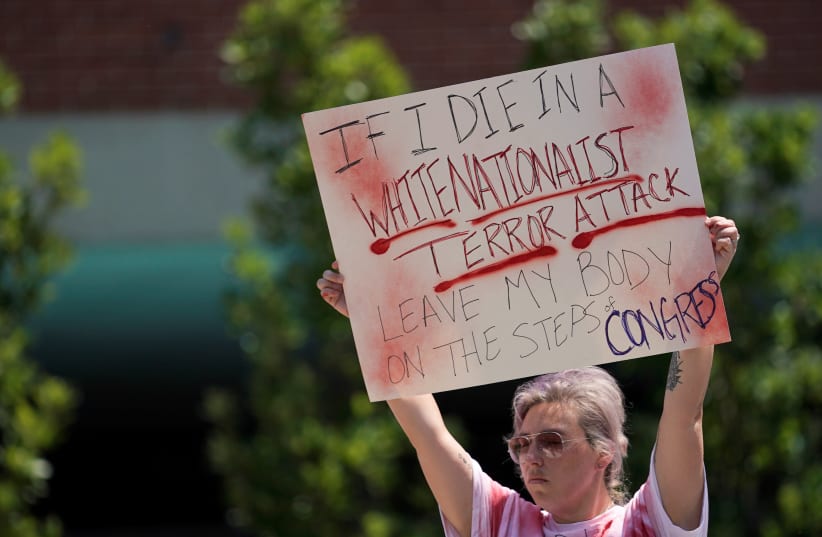 Amanda Luke, of Fairborn, Ohio, holds a sign during a vigil after a mass shooting in Dayton (photo credit: BRYAN WOOLSTON/REUTERS)