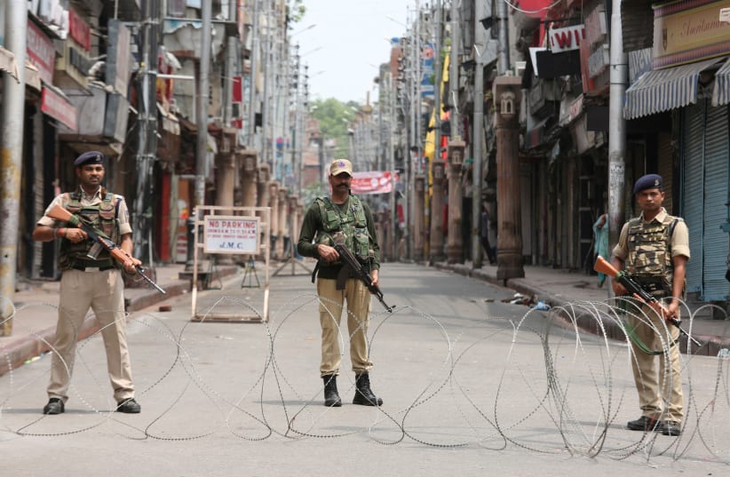 Indian security personnel stand guard along a deserted street during restrictions in Jammu, August 5, 2019 (photo credit: MUKESH GUPTA / REUTERS)