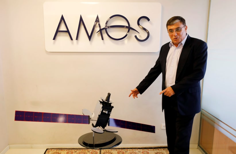 David Pollack, CEO of Israel's Space Communication Ltd, gestures next to a model of Amos-17 satellite at the company offices in Ramat Gan, Israel July 28, 2019 (photo credit: AMIR COHEN/REUTERS)