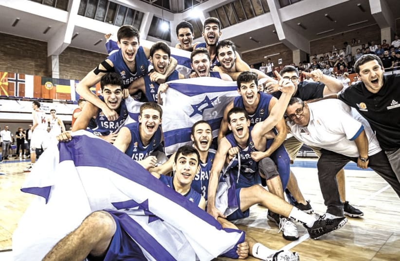 ISRAEL'S UNDER-18 national basketball team celebrates on the court after defeating Poland 81-79 in the Division B final of the European Championships on Sunday night in Romania. The title helps Israel move up to Division A for next year (photo credit: ISRAEL BASKETBALL ASSOCIATION)