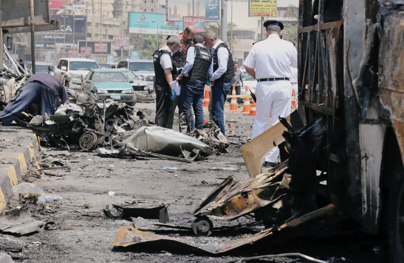 Security officials and investigators inspect the scene of an explosion in Cairo (photo credit: MOHAMED ABD EL GHANY/REUTERS)