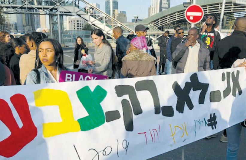 ETHIOPIAN PROTESTERS hold a placard reading ‘I’m not just a color,’ during a demonstration against police brutality in which they blocked Tel Aviv’s Ayalon Highway, on January 30. (photo credit: MARC ISRAEL SELLEM)