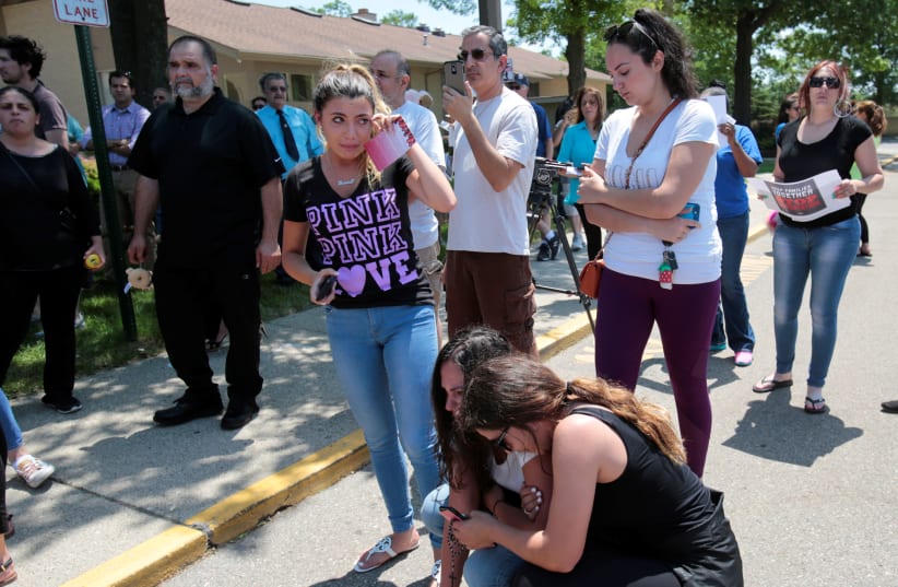 Chaldean-American Lavrena Kenawa cries as she thinks about her uncle who was seized on Sunday by Immigration and Customs Enforcement agents during a rally outside the Mother of God Catholic Chaldean church in Southfield (photo credit: REBECCA COOK / REUTERS)
