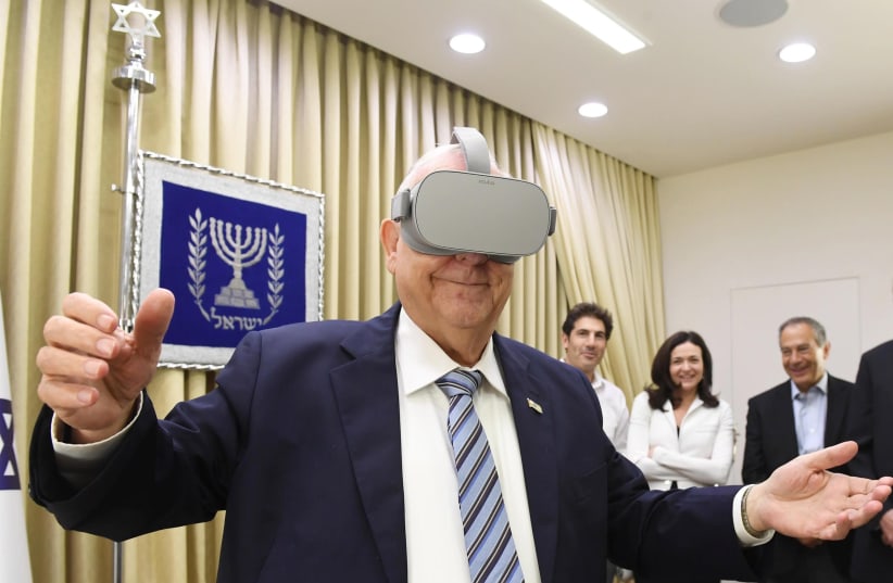President Rivlin tries on virtual reality goggles at meeting with Sheryl Sandberg, 12 August 2019 (photo credit: Mark Neiman/GPO)