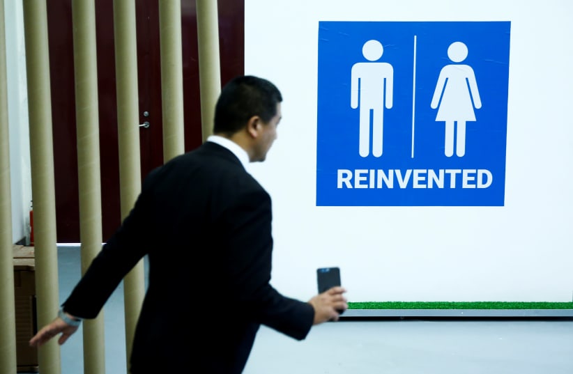 A man walks past a toilet sign at the Reinvented Toilet Expo showcasing sewerless sanitation technology in Beijing (photo credit: REUTERS)