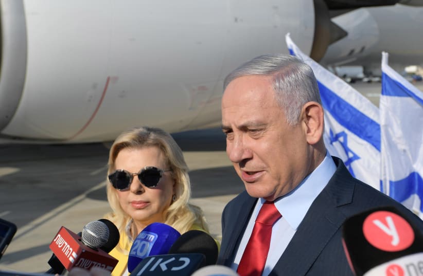 Prime Minister Benjamin Netanyahu speaks to reporters before embarking on a trip to Ukraine with his wife, Sara, August 18, 2019 (photo credit: AMOS BEN-GERSHOM/GPO)