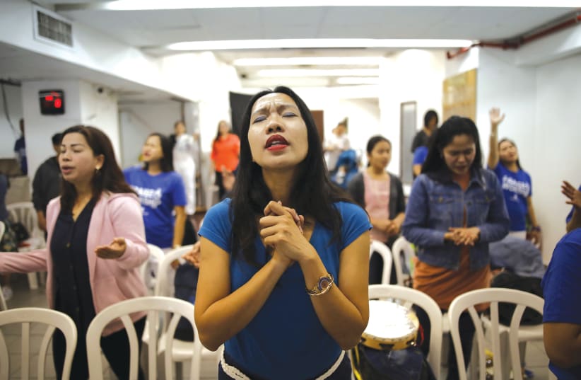 Women pray at a church in Tel Aviv  (photo credit: REUTERS)