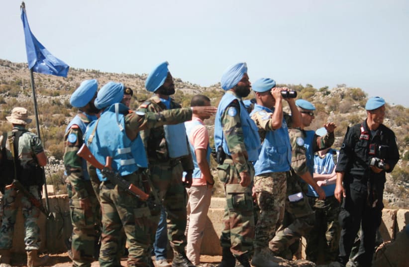 LEBANESE SOLDIERS and UN peacekeepers (blue berets and turbans) serving with UNIFIL inspect areas targeted by IDF shelling in the Shebaa area, southern Lebanon, on October 8, 2014. (photo credit: REUTERS/KARAMALLAH DAHER)