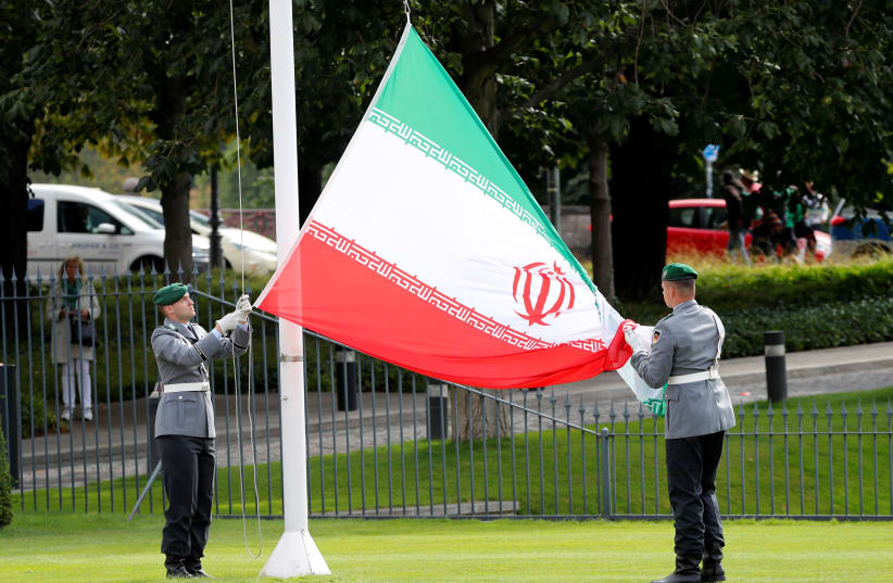 Soldiers of the German armed forces Bundeswehr hold the Iranian flag during a ceremony for the diplomatic accreditation of the new ambassador of Iran to Germany in Berlin (photo credit: FABRIZIO BENSCH / REUTERS)