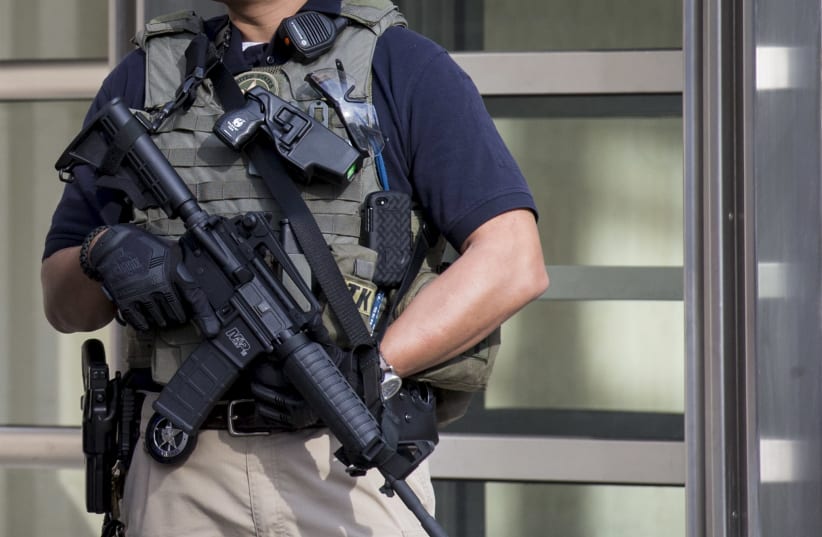 A Federal law enforcement officer stands outside the Brooklyn Federal Courthouse in the Brooklyn borough in New York April 2, 2015. Two New York City women have been arrested in an alleged conspiracy to build a bomb and wage a "terrorist attack" in the United States, according to a federal criminal  (photo credit: BRENDAN MCDERMID/REUTERS)