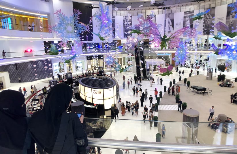 Saudi women use their smartphones in Dubai Mall in Dubai (photo credit: HAMAD I MOHAMMED/REUTERS)