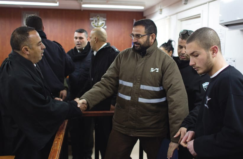 A HAMAS MEMBER shakes hands with his lawyer at the Ofer military court near Givat Ze’ev. (photo credit: RONEN ZVULUN / REUTERS)