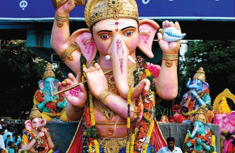 REVELERS SURROUND a statue of Hindu god Ganesh – known as a ‘remover of obstacles’ and god of beginnings – during a contemporary festival. (photo credit: Wikimedia Commons)