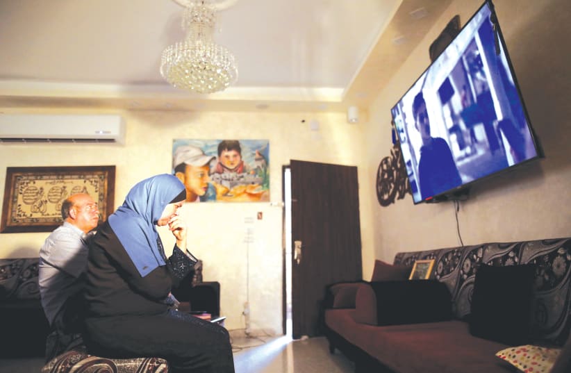 Hussein and Suha Abu Khdeir, whose son’s murder is the subject of the HBO series ‘Our Boys’, watch the show’s first two episodes in their East Jerusalem home in mid August. (photo credit: REUTERS/AMMAR AWAD)
