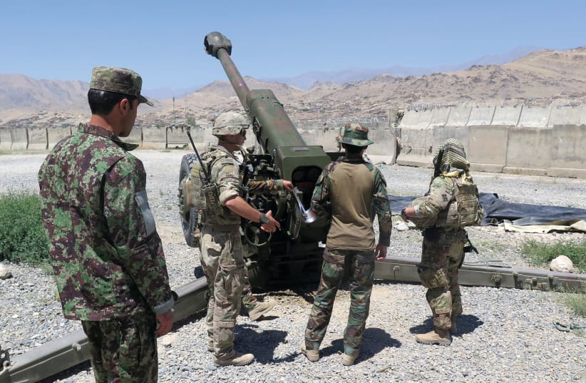US MILITARY advisers from the 1st Security Force Assistance Brigade work with Afghan soldiers at an artillery position on an Afghan National Army base in Maidan Wardak province, Afghanistan in 2018 (photo credit: REUTERS)