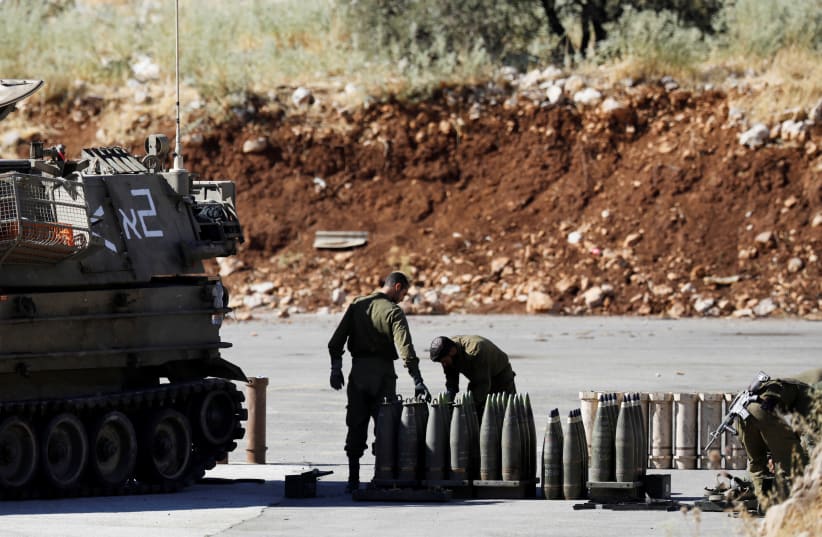 Israeli soldiers stand next to shells and a mobile artillery unit near the Israeli side of the border with Syria in the Israeli-occupied Golan Heights (photo credit: REUTERS)