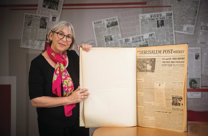 ‘International Jerusalem Post’ editor Liat Collins holds a bound volume open at the first edition of the paper, 60 years ago, with a letter from  David Ben-Gurion in the center.  (photo credit: YONATAN SINDEL/FLASH 90)