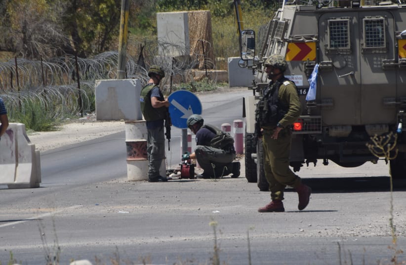 IDF soldiers and bomb technicians after disarming the bomb at the 'Focus' Checkpoint near the entrance to the community of Beit El in Binyamin. Aug 03, 2016 (photo credit: INBAL REUVENI/ TPS)